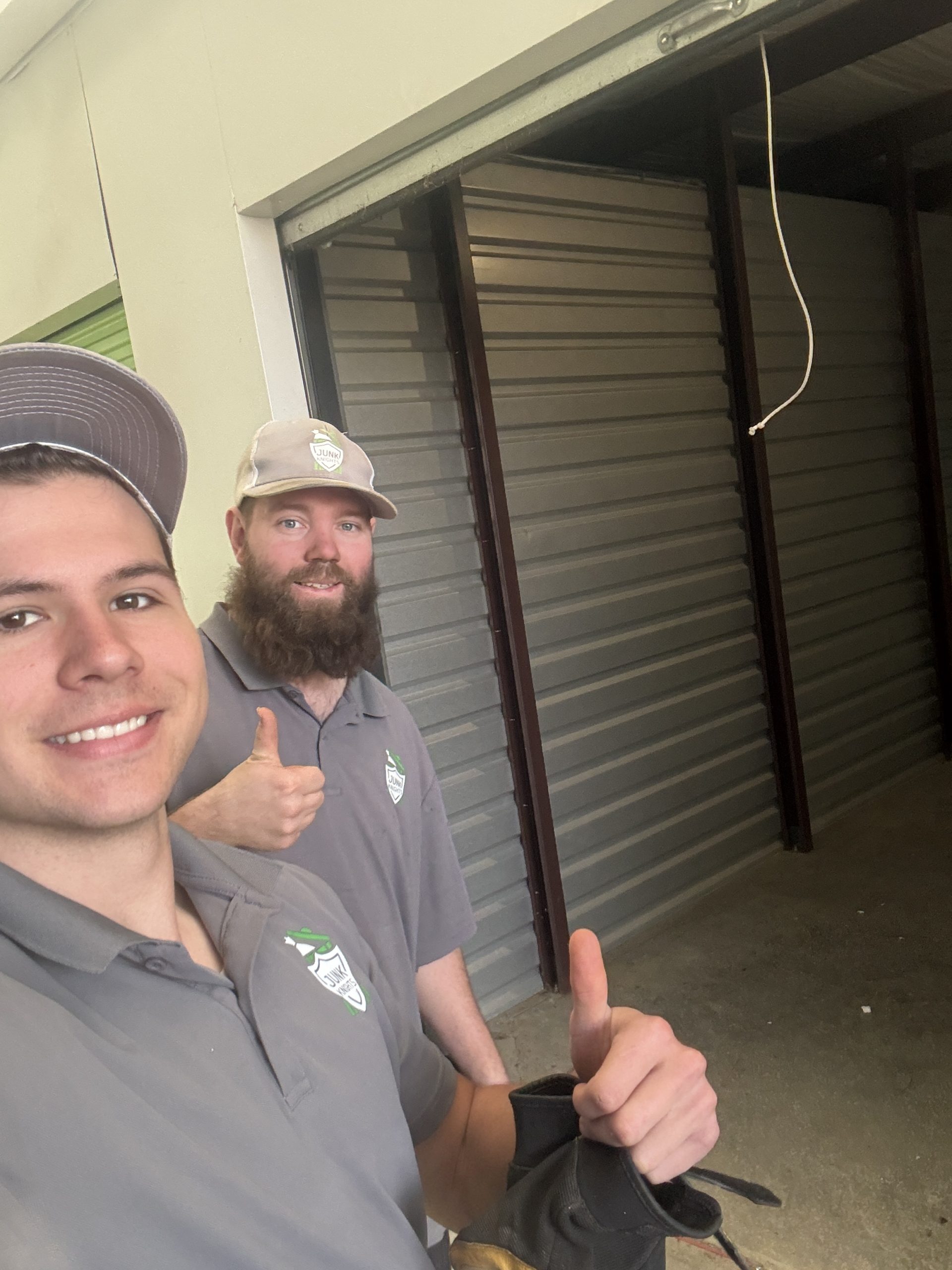 Devin and Emory smiling in front of an empty storage unit