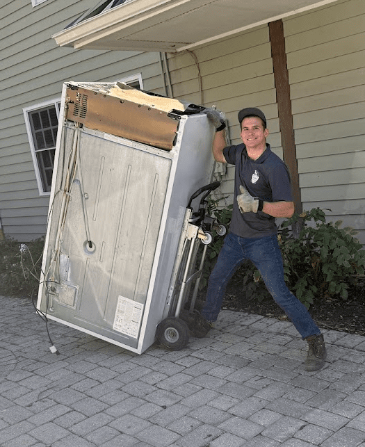 Emory hauling a refrigerator on a dolly