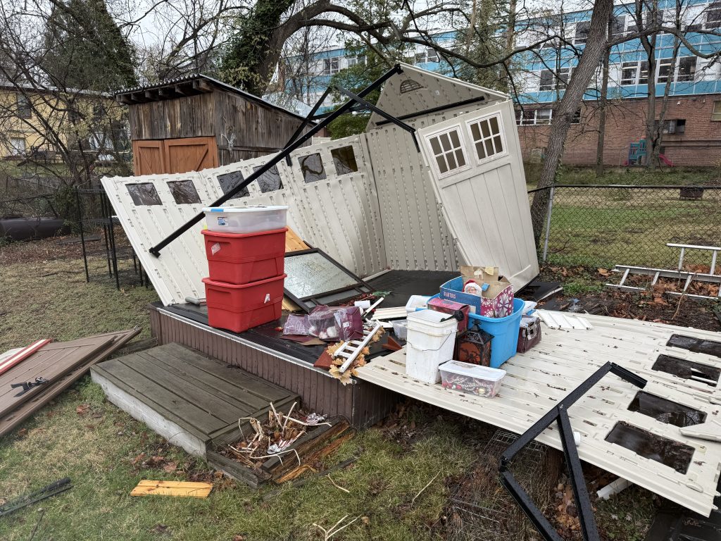 An old plastic shed leaning and falling apart in a backyard
